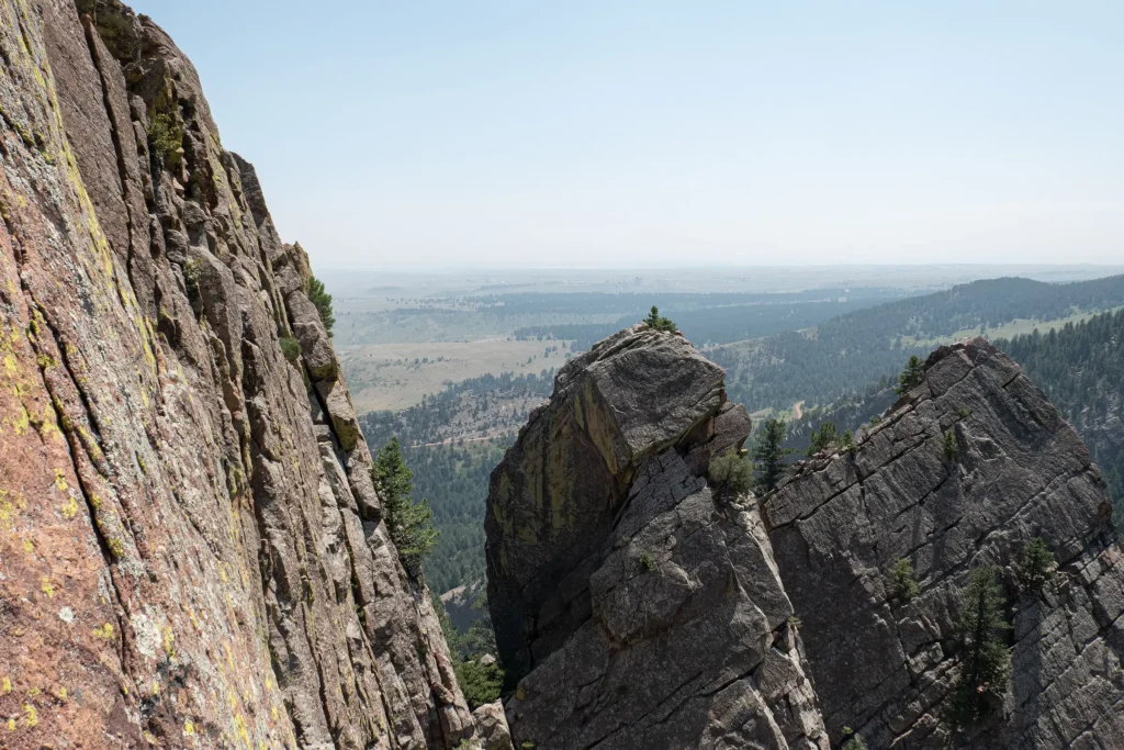 View of tower one from the final pitch of Rewritten in Eldorado Canyon. The slopes of the front range are visible in the distance.
